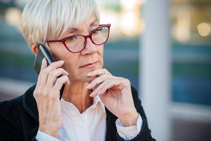 Worried mature businesswoman talking on the mobile phone