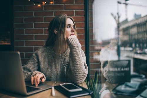 une jeune fille surdiplômée assise dans un café en recherche d'emploi