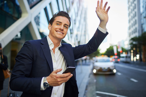 a business man in a suit, waving at a taxi and thinking about internal mobility